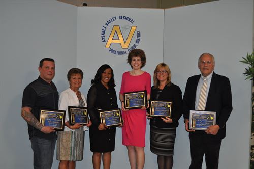Hall of Achievement winners pose in a group with their plaques